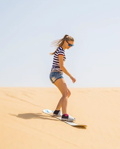 Tourist sand surfing in the desert